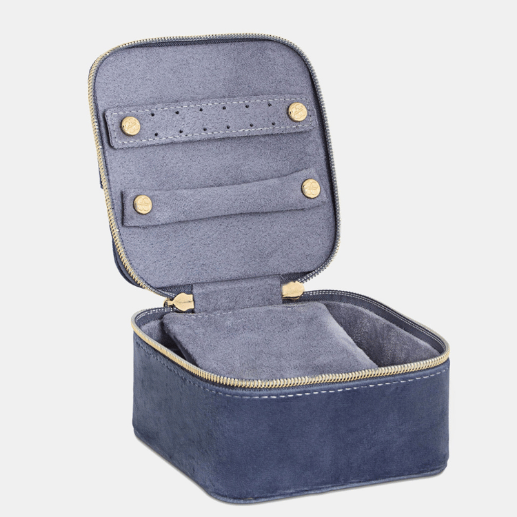 Open blue velvet jewellery case displaying multiple storage sections for rings, earrings, and necklaces