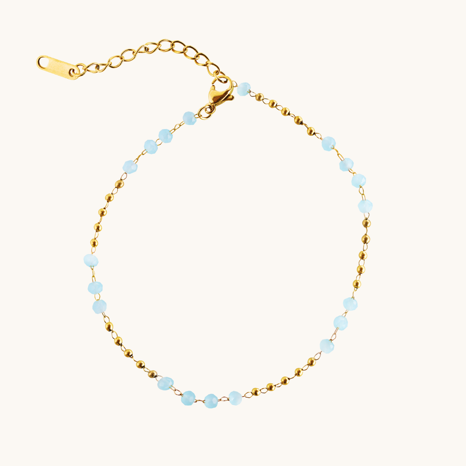 Blue and gold beaded anklet on cream background
