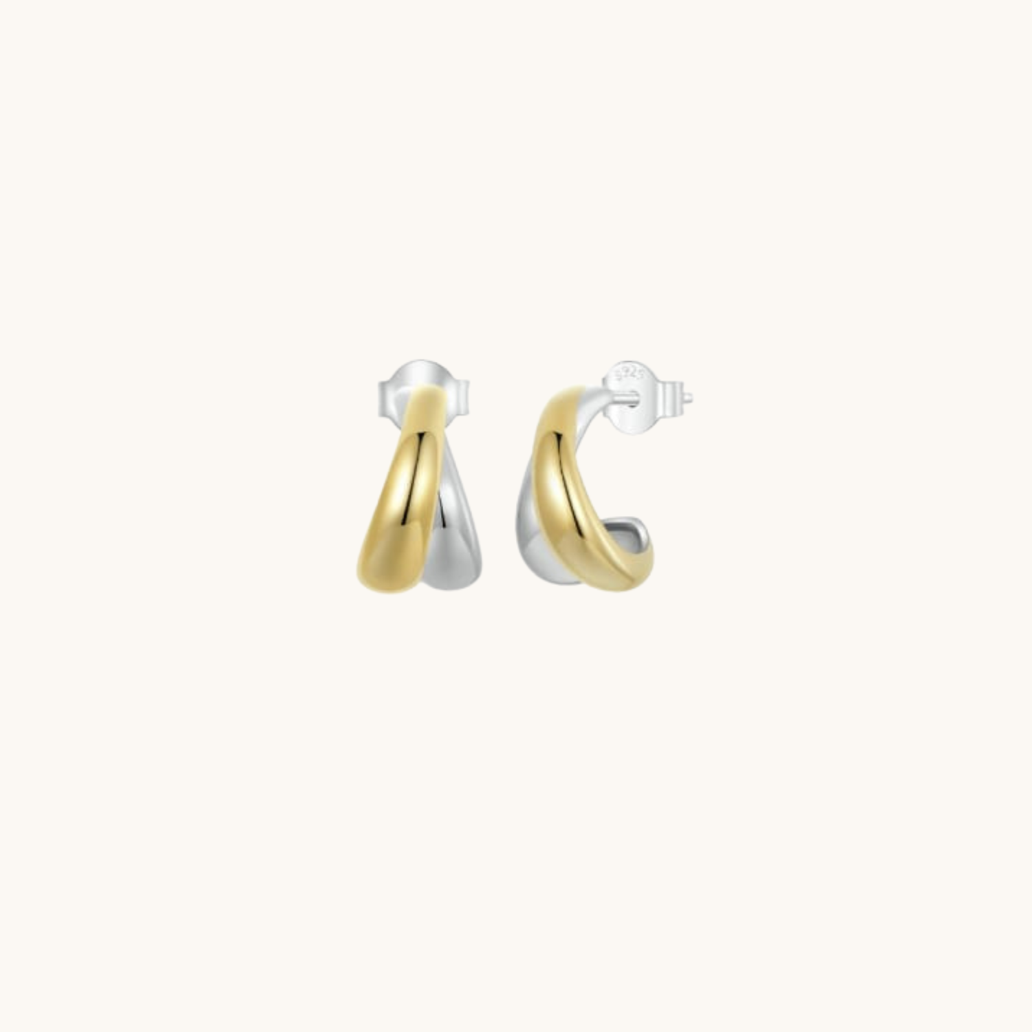 Pair of gold and silver earrings on a white background