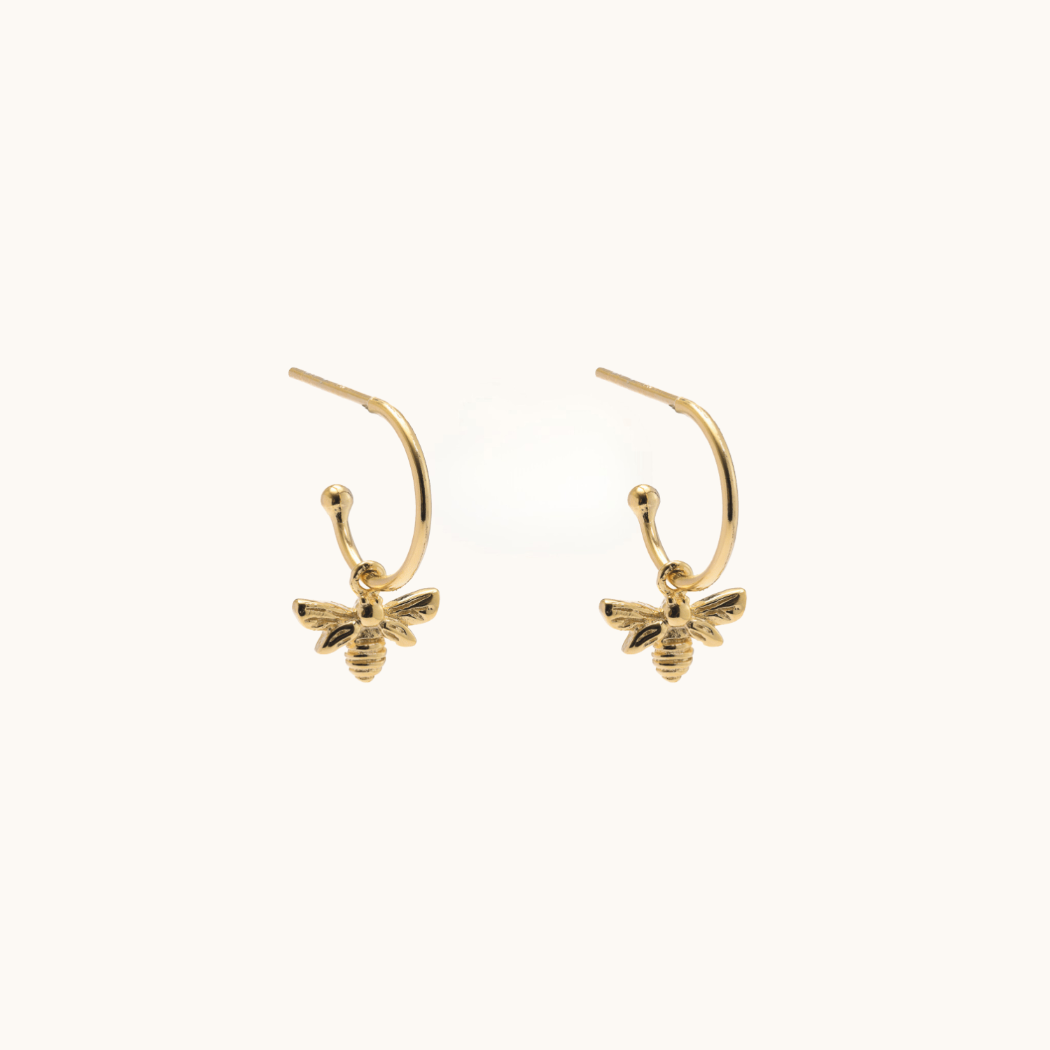Gold bee-shaped earrings on a white background
