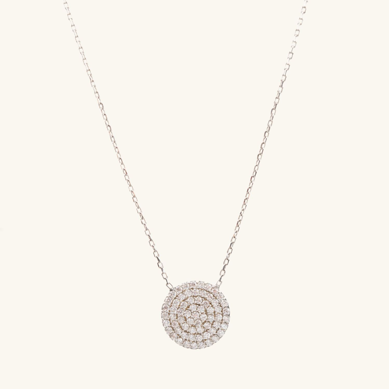 Sterling silver necklace with a delicate circular pendant filled with sparkling cubic zirconia stones, displayed on a neutral background.