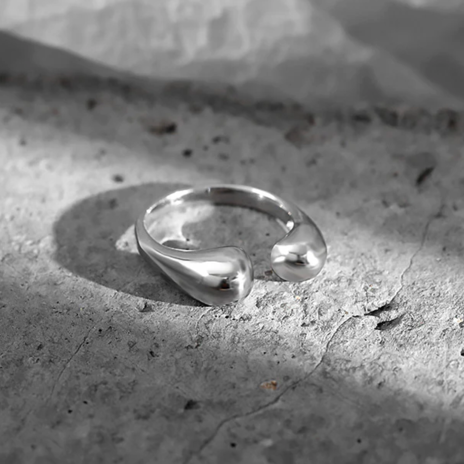 Silver ring with a unique design on a textured stone surface