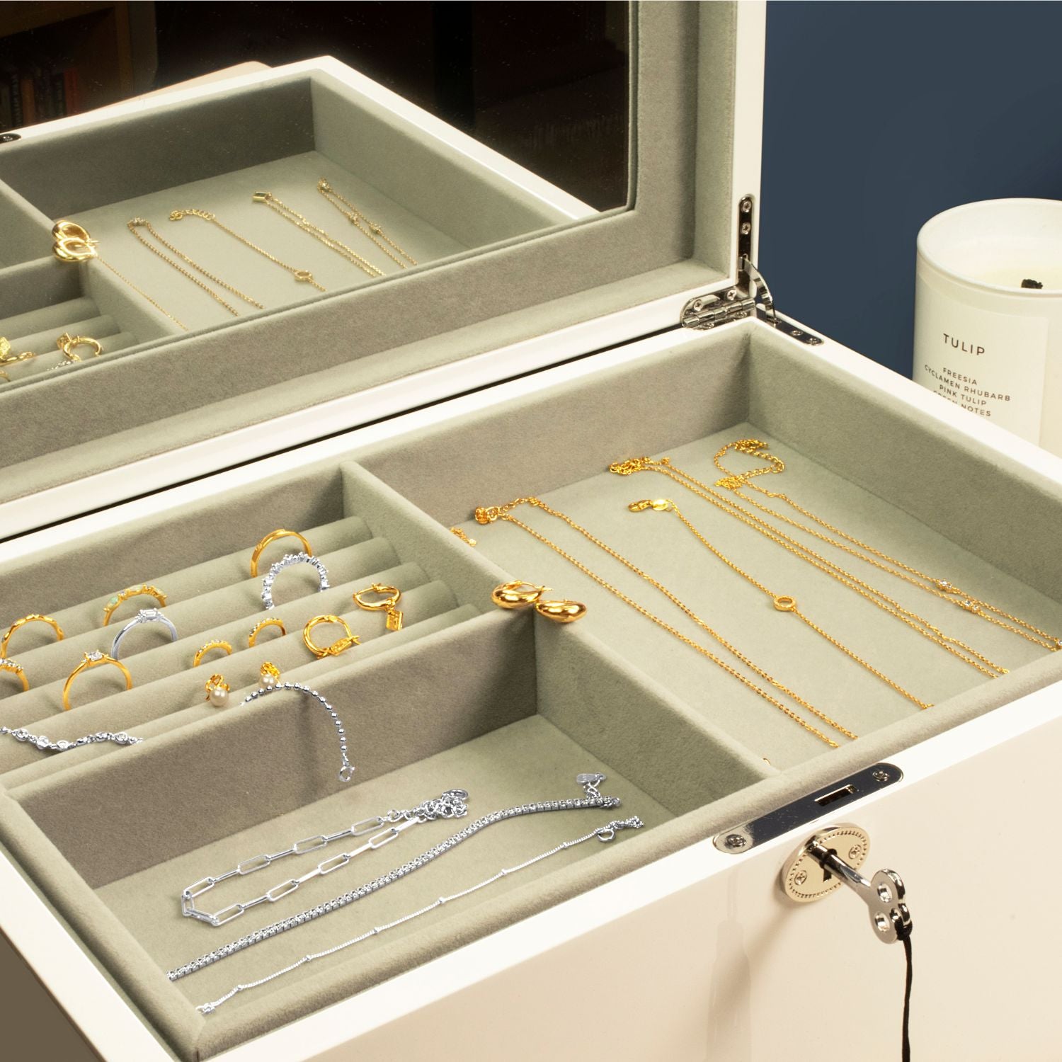 Jewellery neatly arranged on storage trays inside a white multi-compartment jewellery box, featuring sections for rings, necklaces, and accessories.