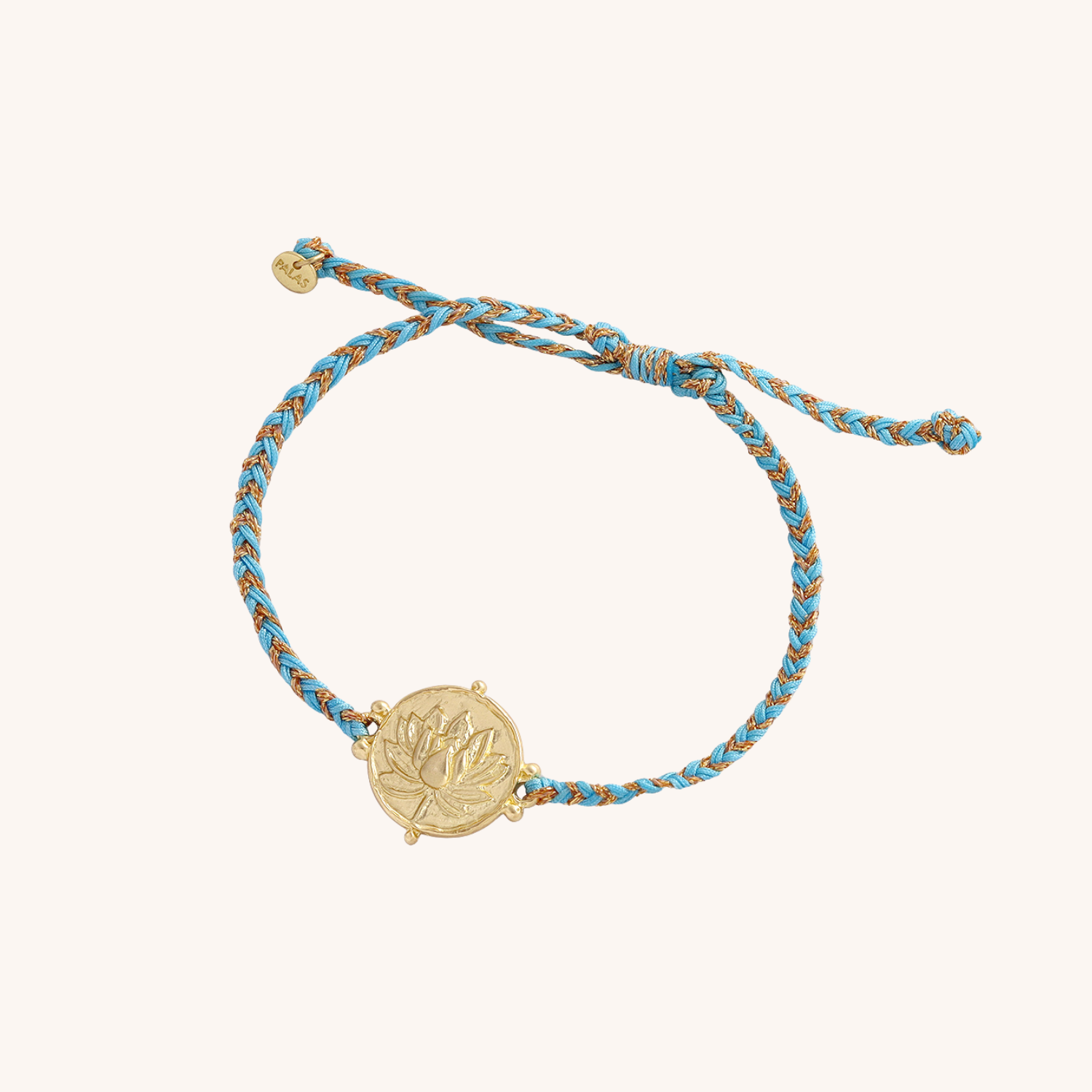 Bracelet with gold charm and blue braided cord on a white background