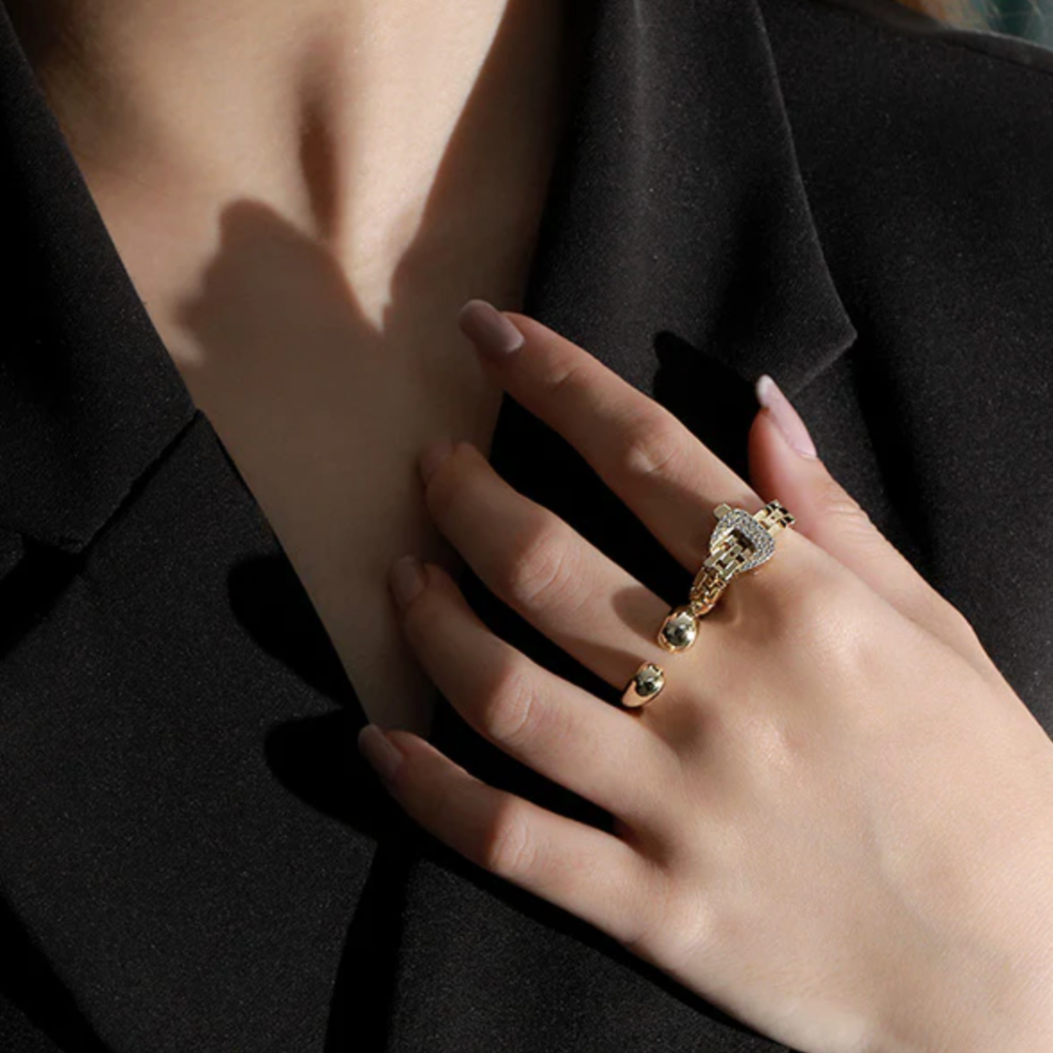 Hand wearing a silver ring with a black background