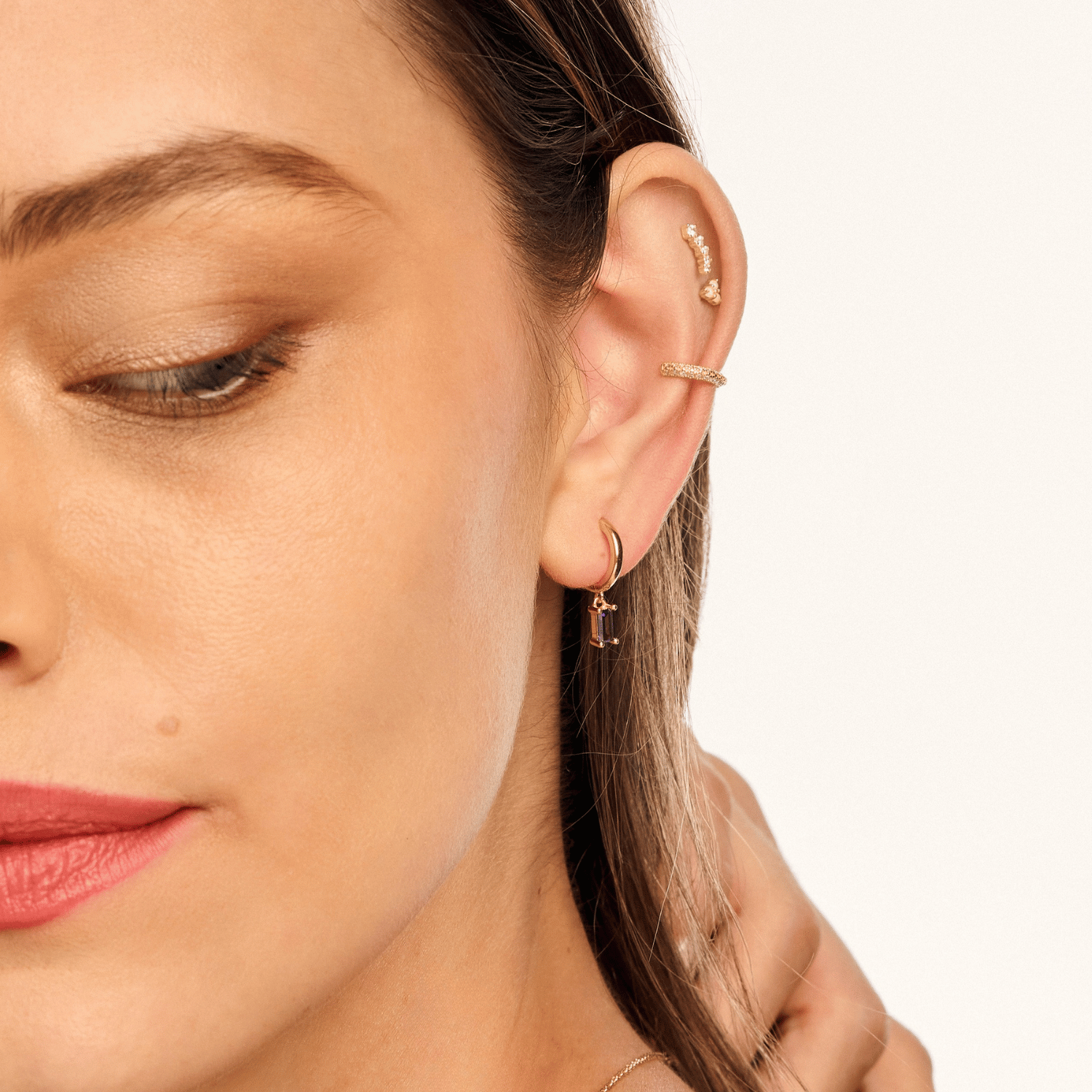 Model wearing a Moonstone Lotus earring, styled with other earrings from our collection,