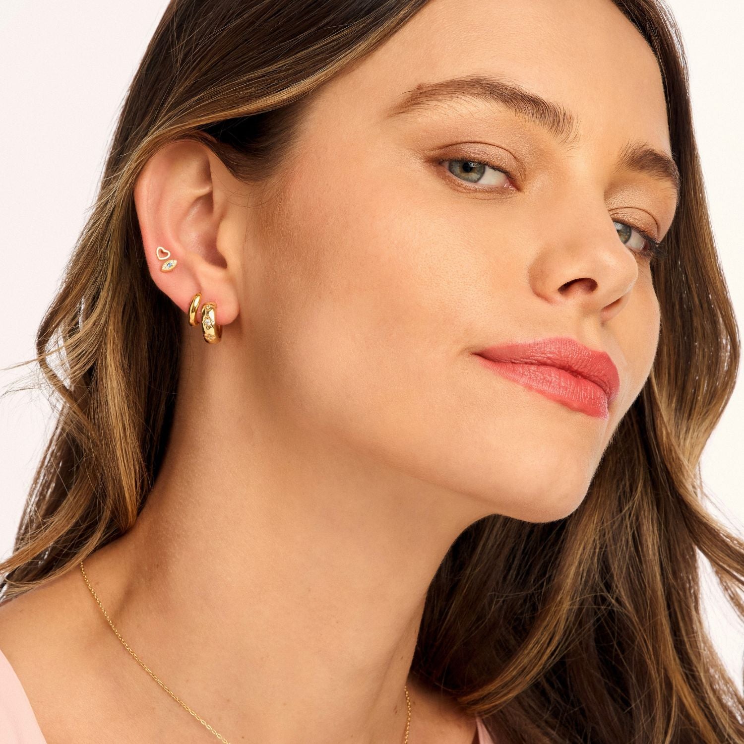 Model wearing Stargazer Huggie Earrings, showcasing their thick, star-adorned band with shimmering cubic zirconia for a celestial-inspired statement.