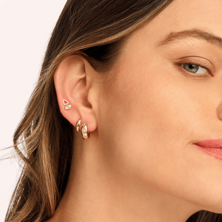 Model wearing Essential Huggie Earrings, showcasing their sleek, lightweight design in sterling silver or gold-plated for effortless, everyday elegance