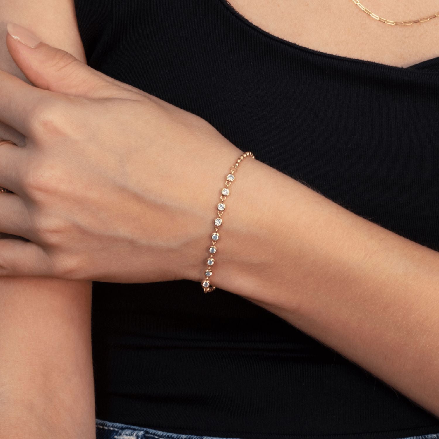 Model wearing gold bracelet with rhinestones and polished ball details – delicate and refined jewellery look