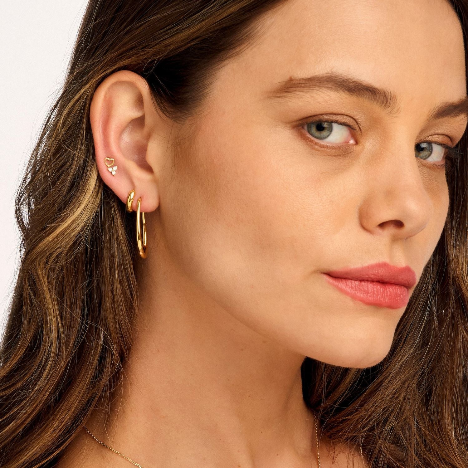 Model wearing gold lotus cubic zirconia earrings, showcasing their delicate floral design and sparkling stones for an elegant, timeless look