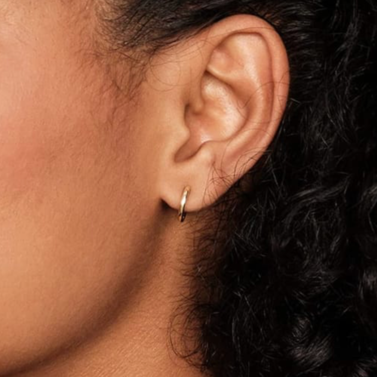 Model wearing Linea Huggy earrings