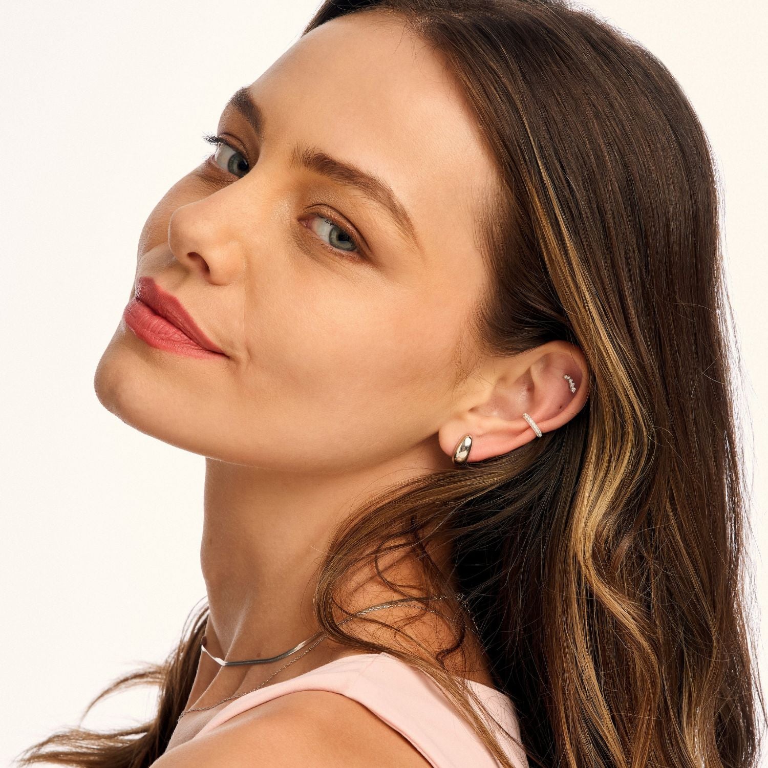 Model wearing large silver dome stud earrings, showcasing their bold, minimalist design. A statement piece that adds modern elegance to any look
