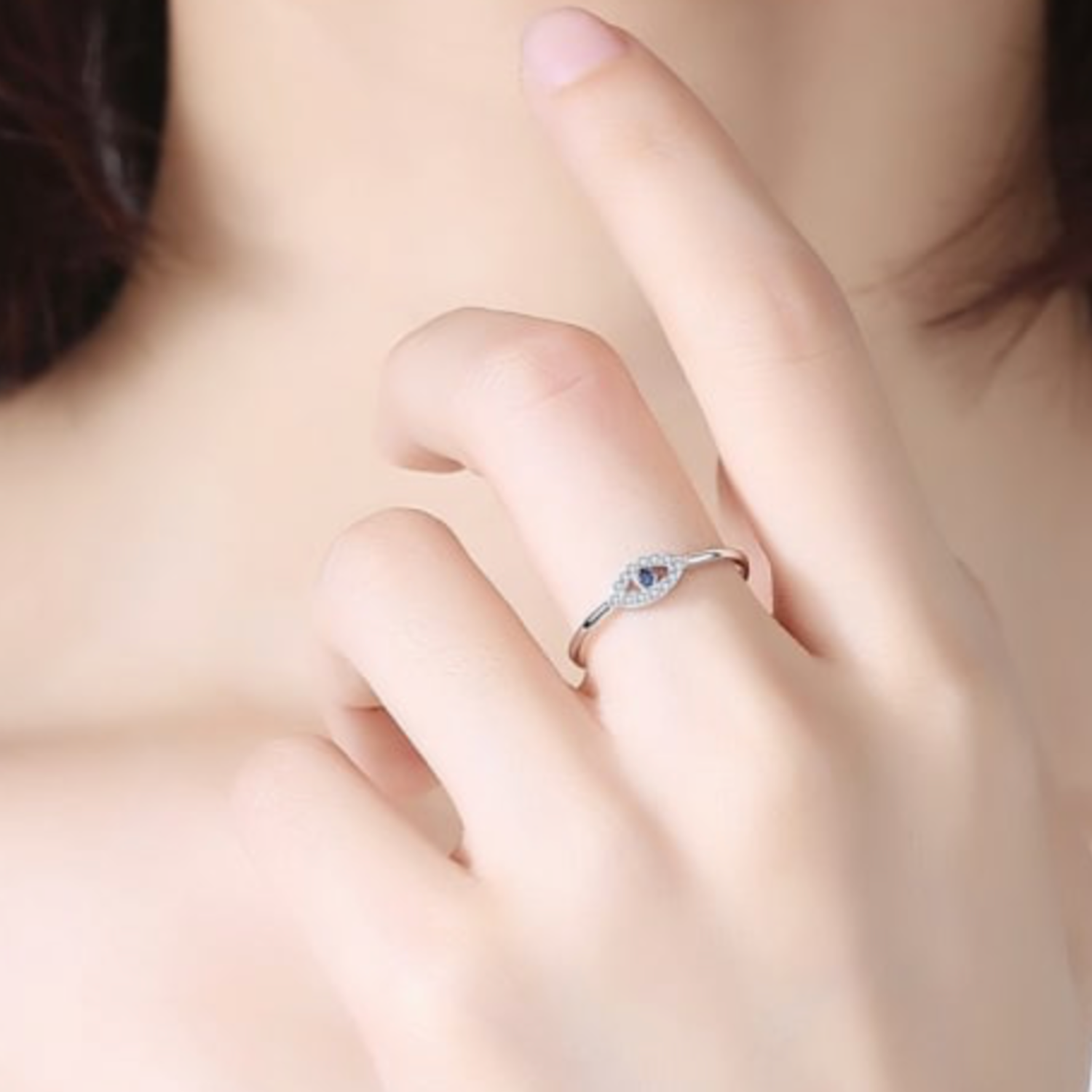 Close-up of a hand wearing a silver ring with a blue gemstone.