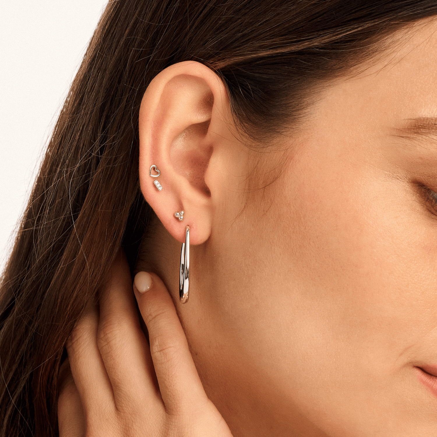 Model wearing a Small Bar cubic zirconia earring, styled with other pieces from our collection