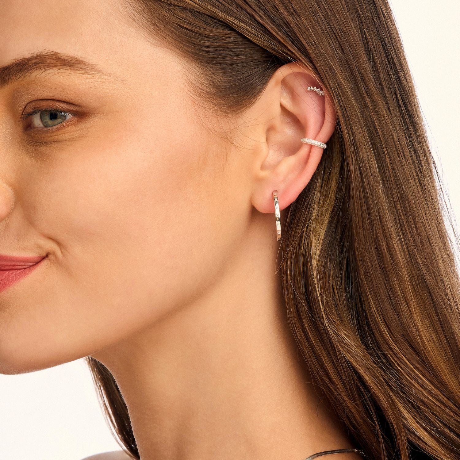 Model wearing silver decorative hoop earrings, highlighting their elegant detailing and timeless appeal. A versatile accessory for any occasion