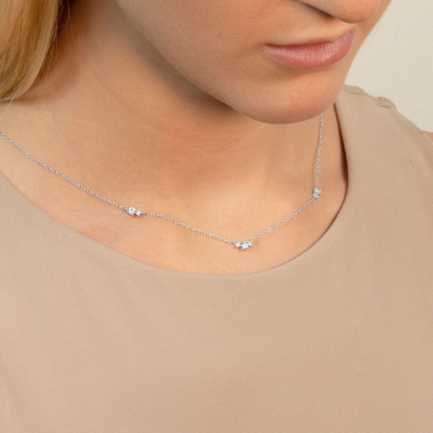 Model wearing a floating cubic zirconia necklace on a delicate silver chain, highlighting its minimalist elegance and timeless sparkle