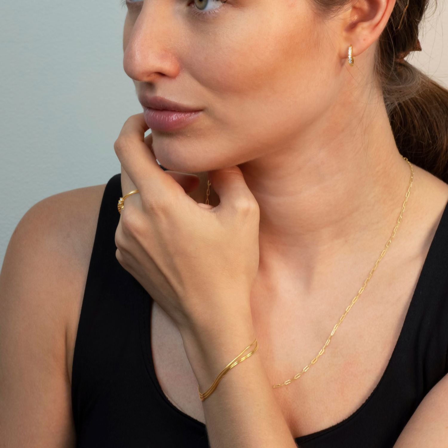 Model wearing a gold multi-strand bracelet – elegant and chic layered jewellery style.