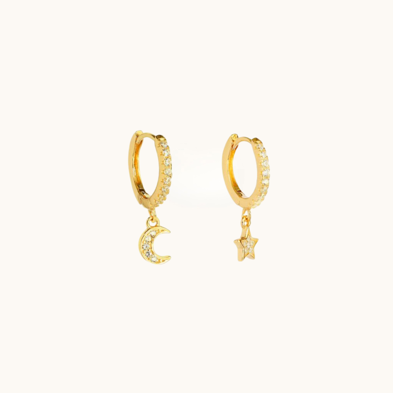 Gold hoop earrings with moon and star charms on a white background