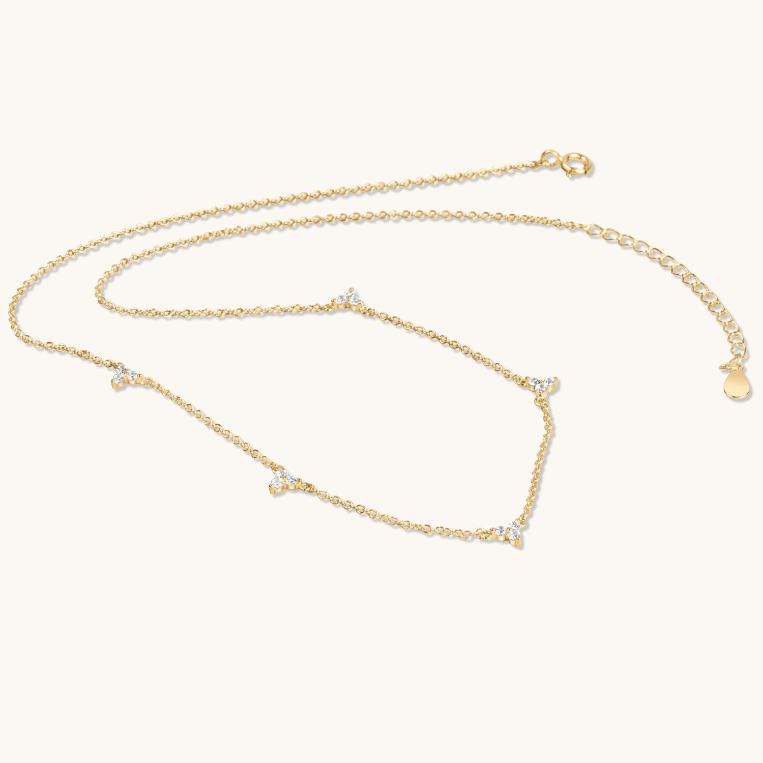 multi lotus gold flower necklace flat on cream background