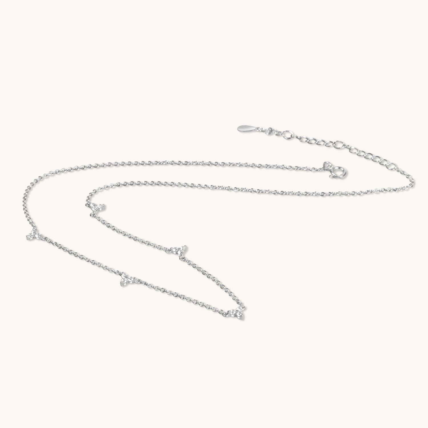 multi lotus silver flower necklace flat on cream background