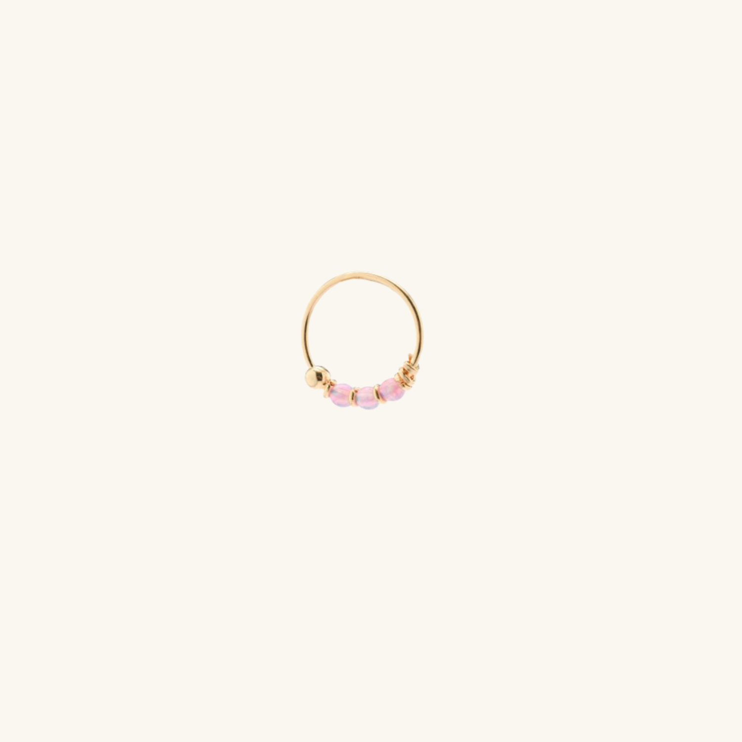Gold Helix Earring with pink opalite on a light beige background