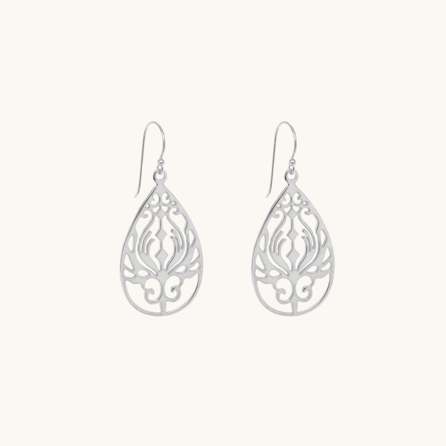 Pair of silver teardrop earrings with intricate filigree design on a white background