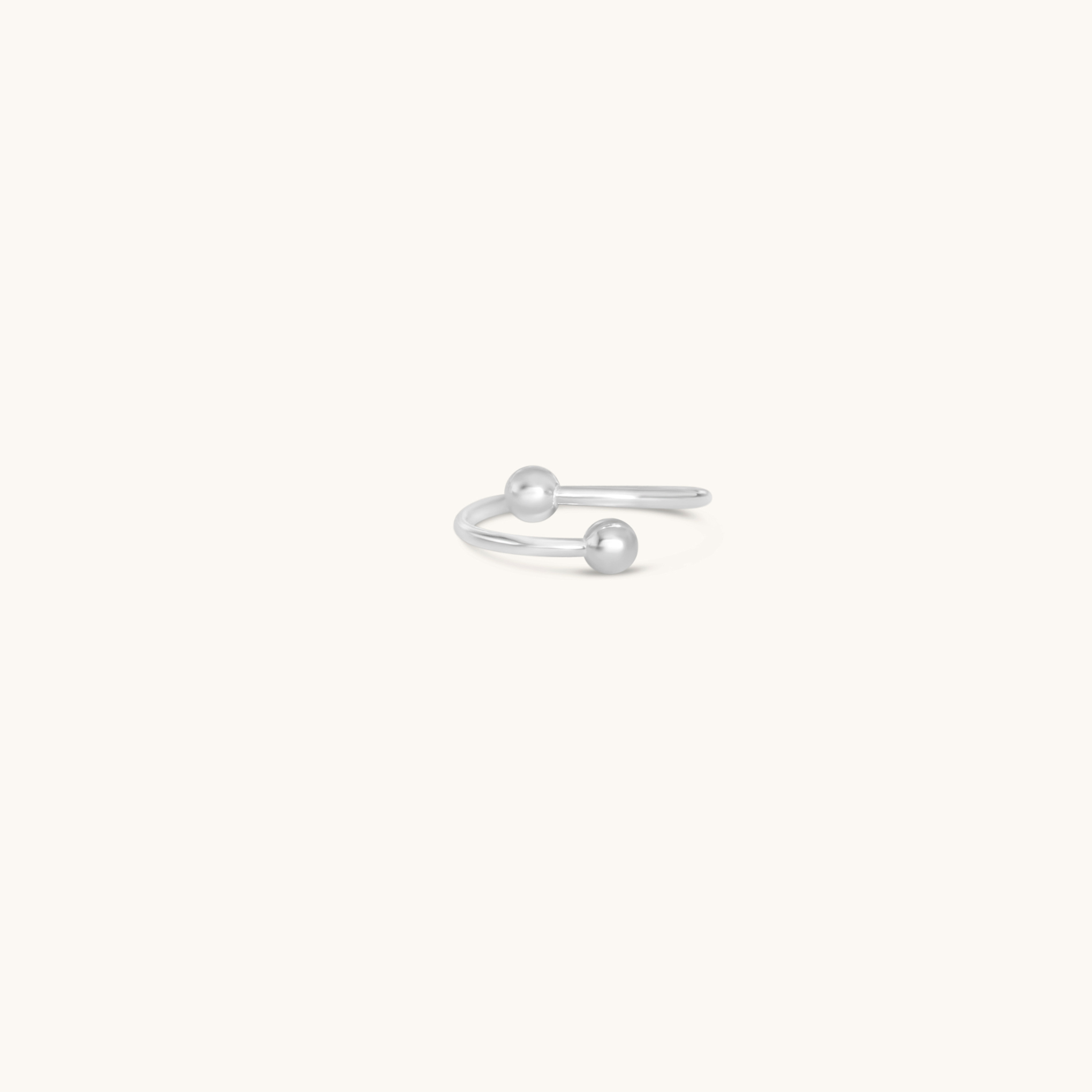 Silver open toe ring with a small ball on a white background