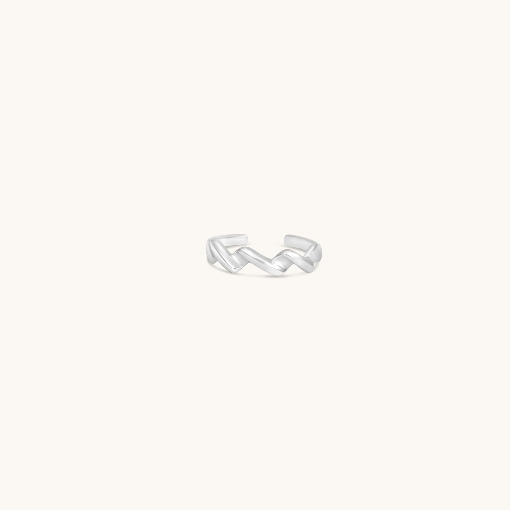 Silver ring with a unique wave design on a white background
