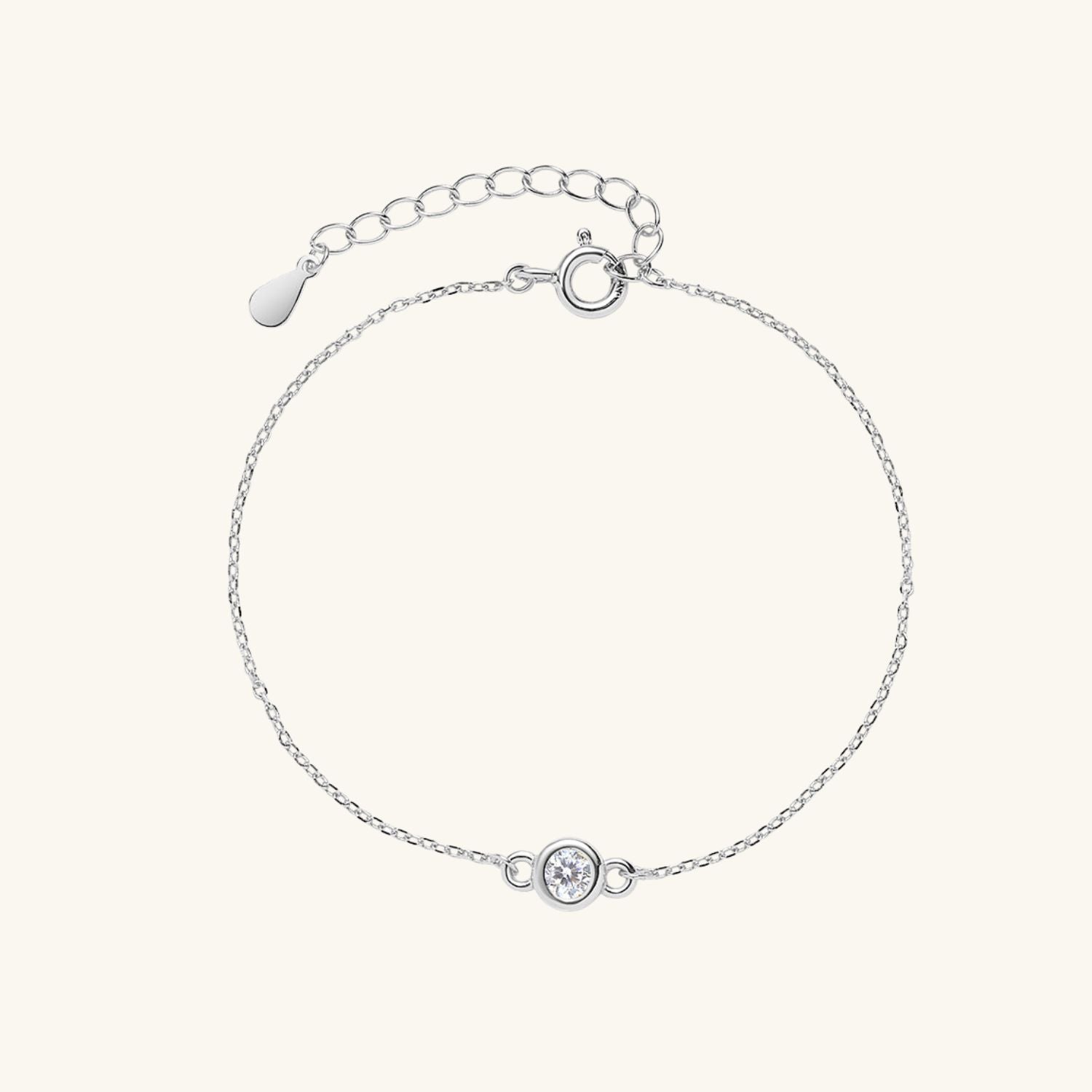 Silver bracelet with a small round zircon on a cream background
