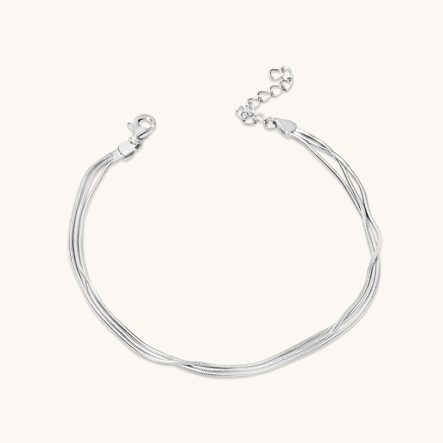 Flat lay of a silver multi-strand bracelet displayed on a neutral background – modern, layered jewellery style.