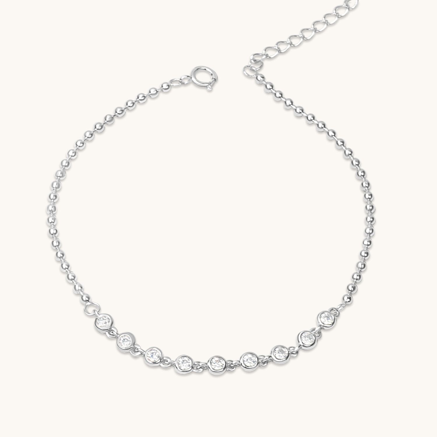 Silver bracelet featuring rhinestones and polished ball accents, styled on a neutral background.