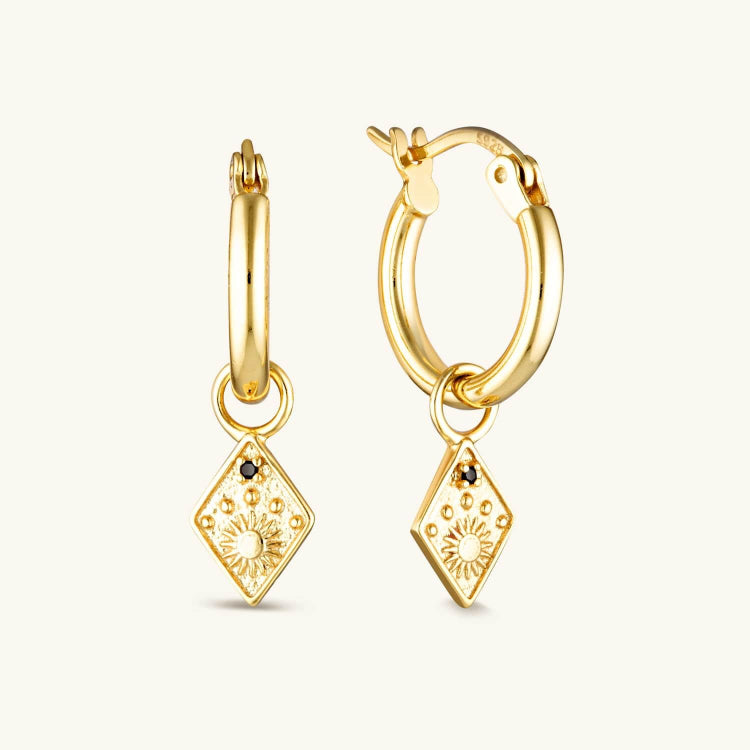 Gold-plated Solstice Huggie Earrings with a diamond-shaped drop, featuring a radiant sun emblem and star for a celestial-inspired look