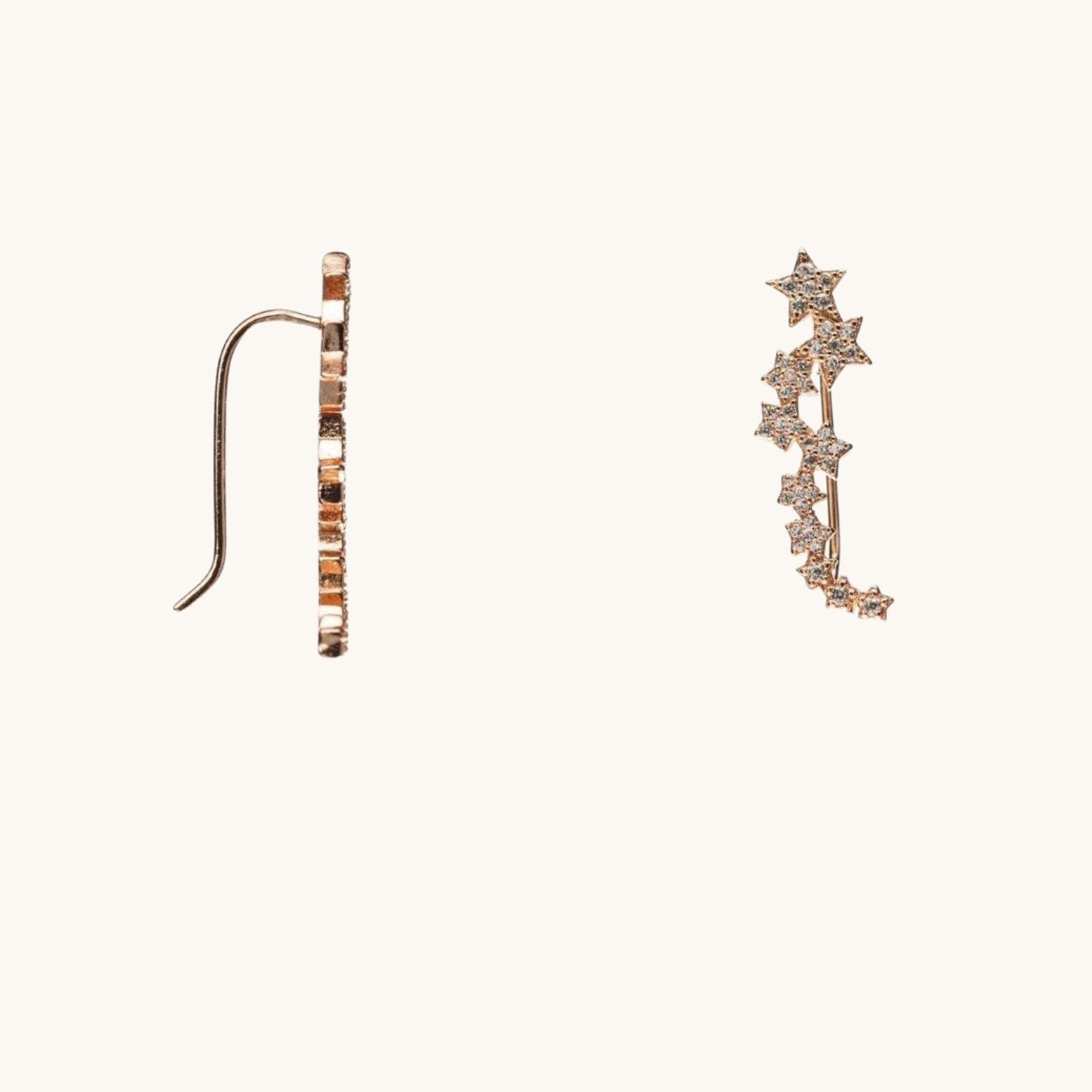 Star cuff earrings shown from the side with earring back, displayed on cream background