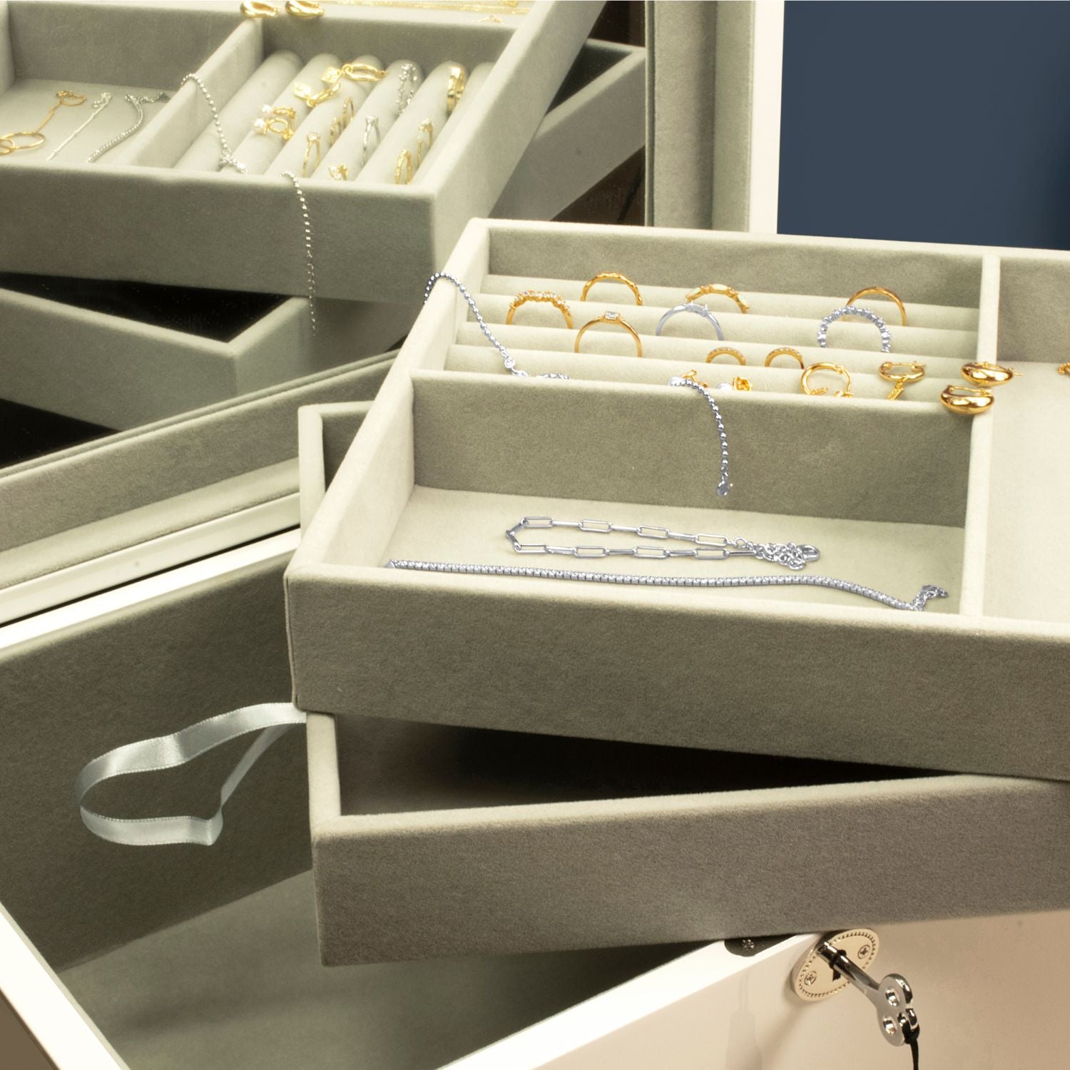 White multi-compartment jewellery box with storage trays, revealing sections for rings, necklaces, and accessories, designed for organised and elegant jewellery storage