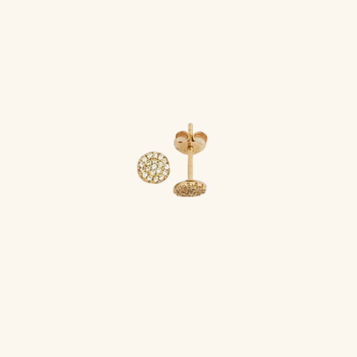 Gold CZ earrings on a light beige background