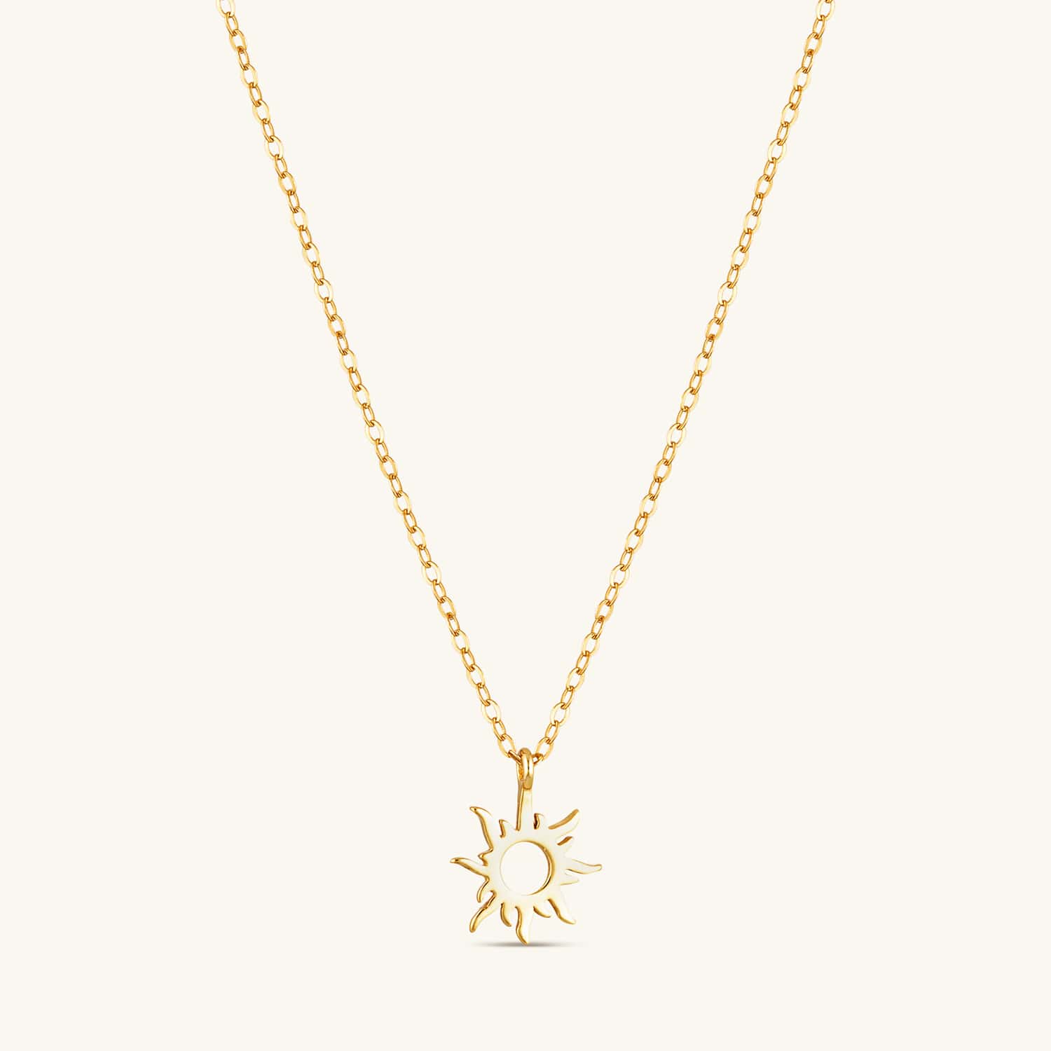 Gold sunburst necklace with a radiant emblem on a delicate chain, featuring a polished finish for an elegant and timeless look