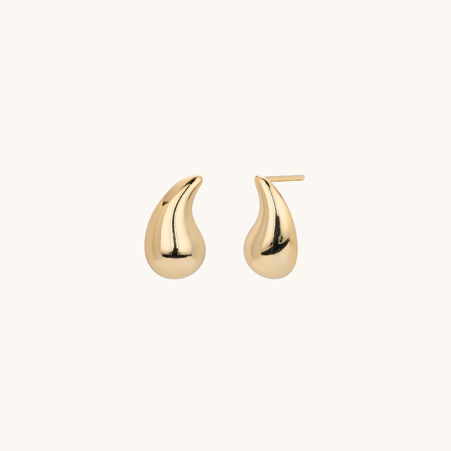 A pair of polished gold teardrop-shaped stud earrings on a clean, off-white background.