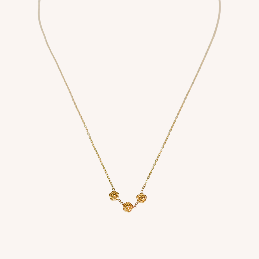 Gold necklace with rose-shaped pendants on a white background