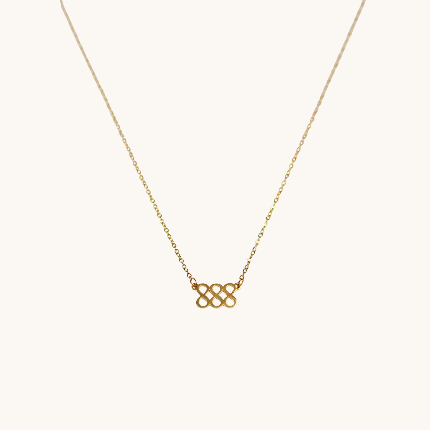Gold necklace with a triple 8 pendant on a white background