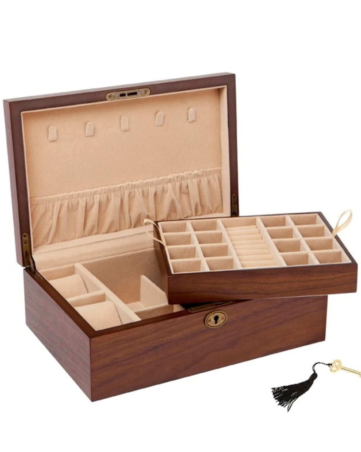 A wooden jewelry box with a dark brown wood grain exterior and a beige velvet interior, shown open with a sliding tray and compartments. A small black tassel with a gold ring is placed in front on a white background.