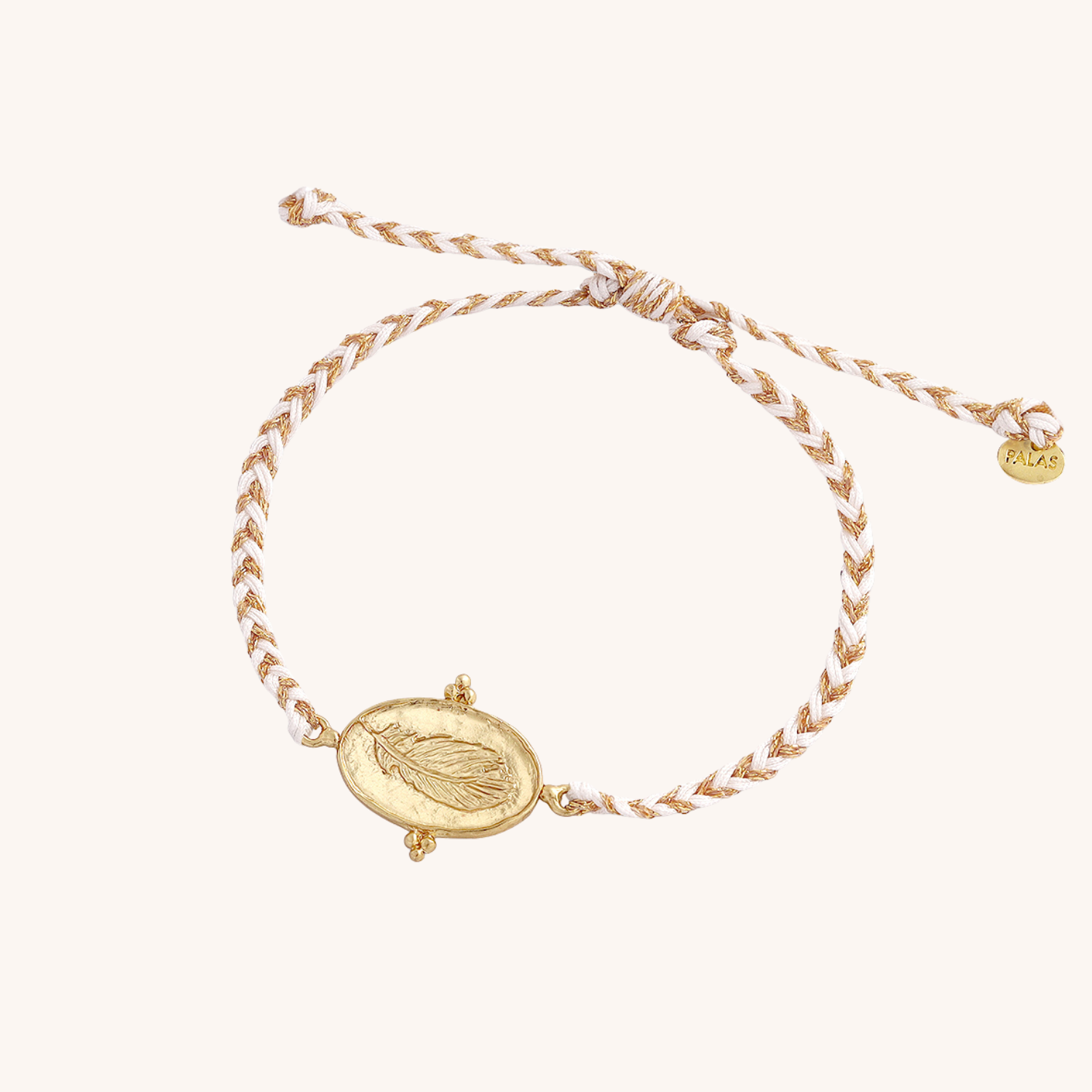 Gold bracelet with a featherr pendant on a white background