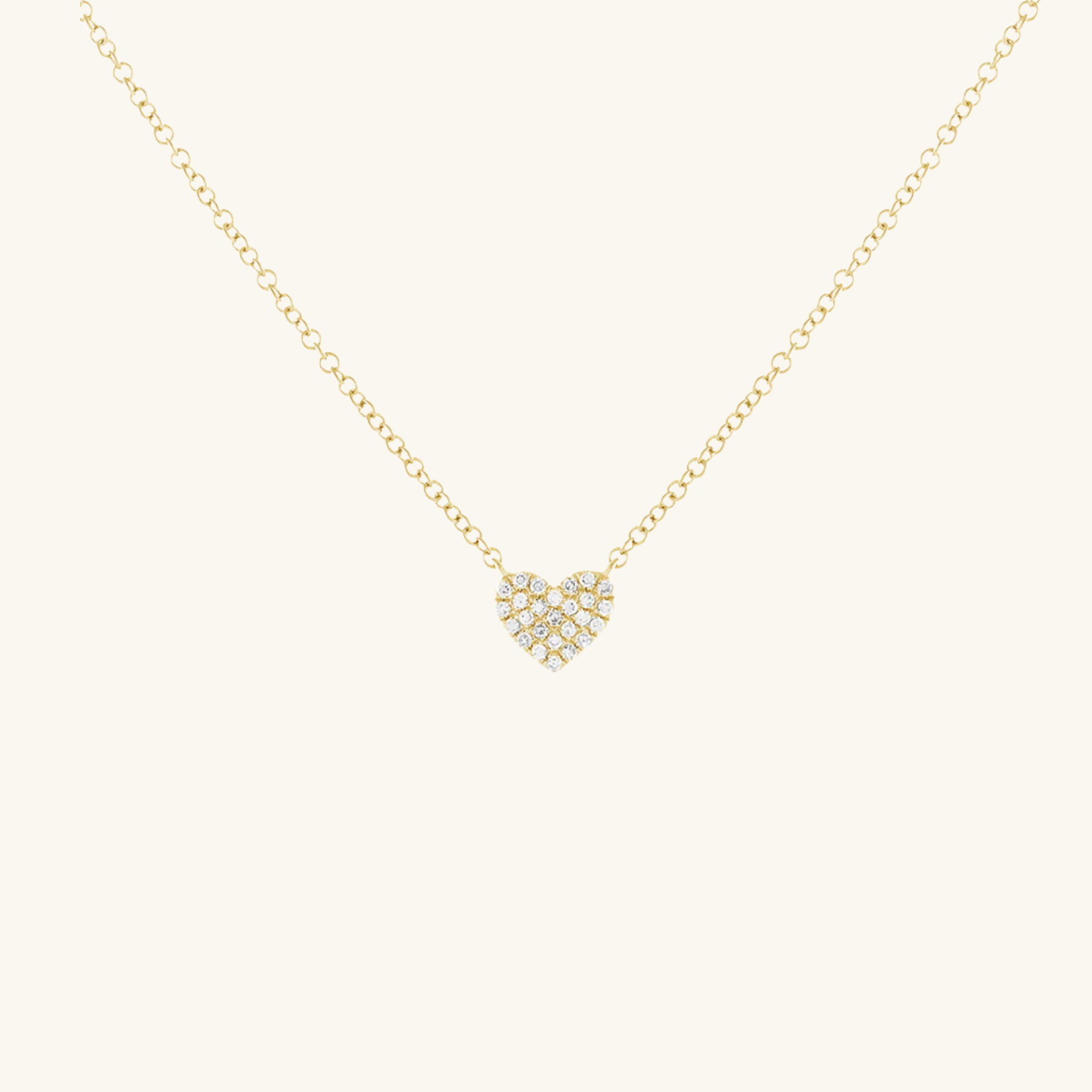 Gold necklace with a heart-shaped pendant on a white background