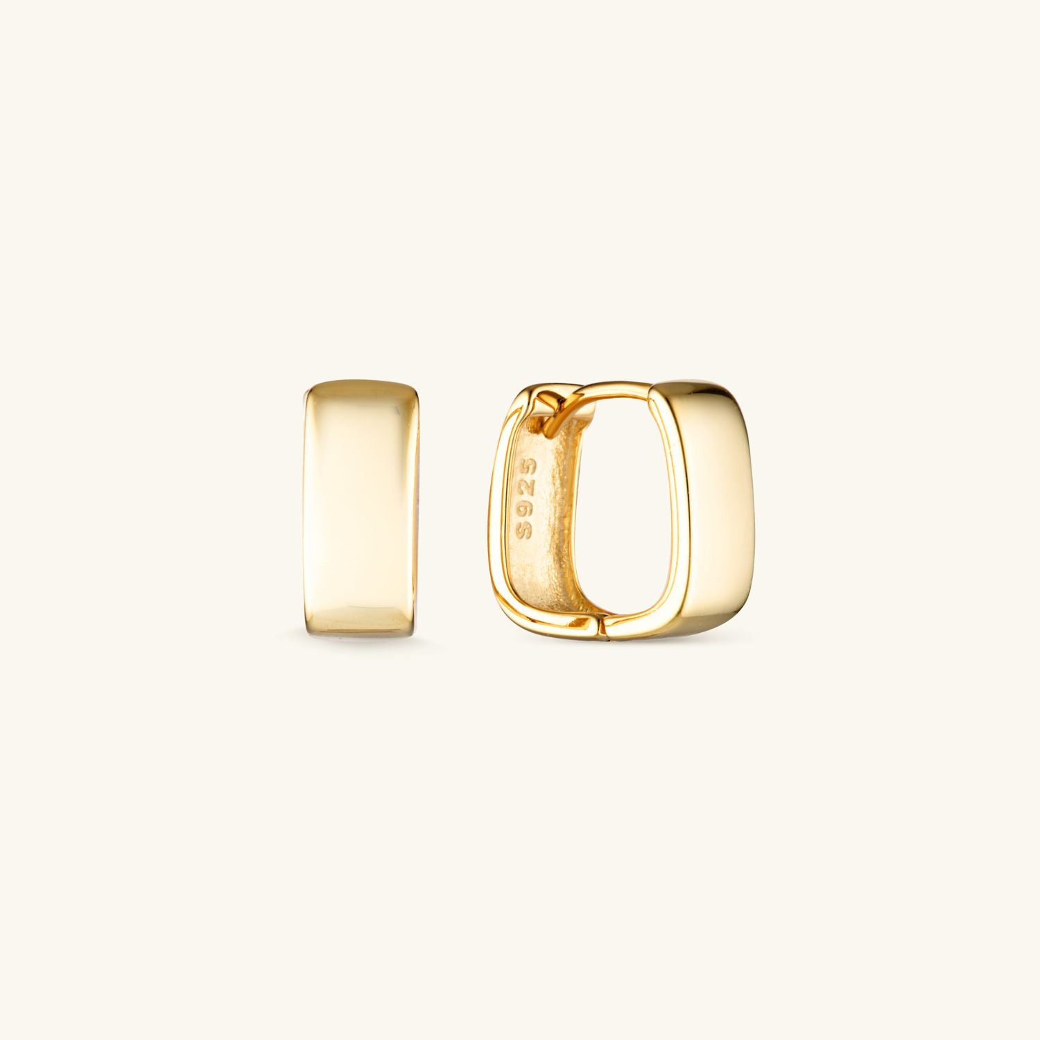 Gold icon Huggie earrings with square cube shape, displayed against a neutral background