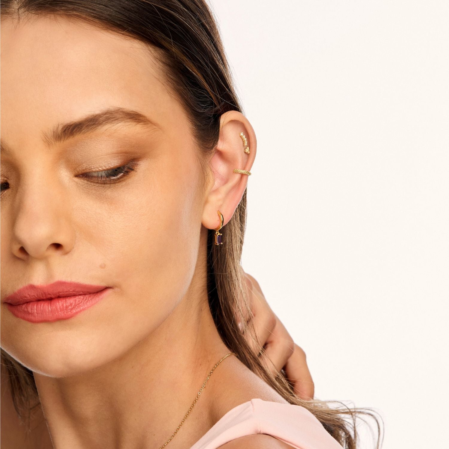 Model wearing Zephyr Huggie Earrings, showcasing their bold geometric drop design for a sleek, modern look
