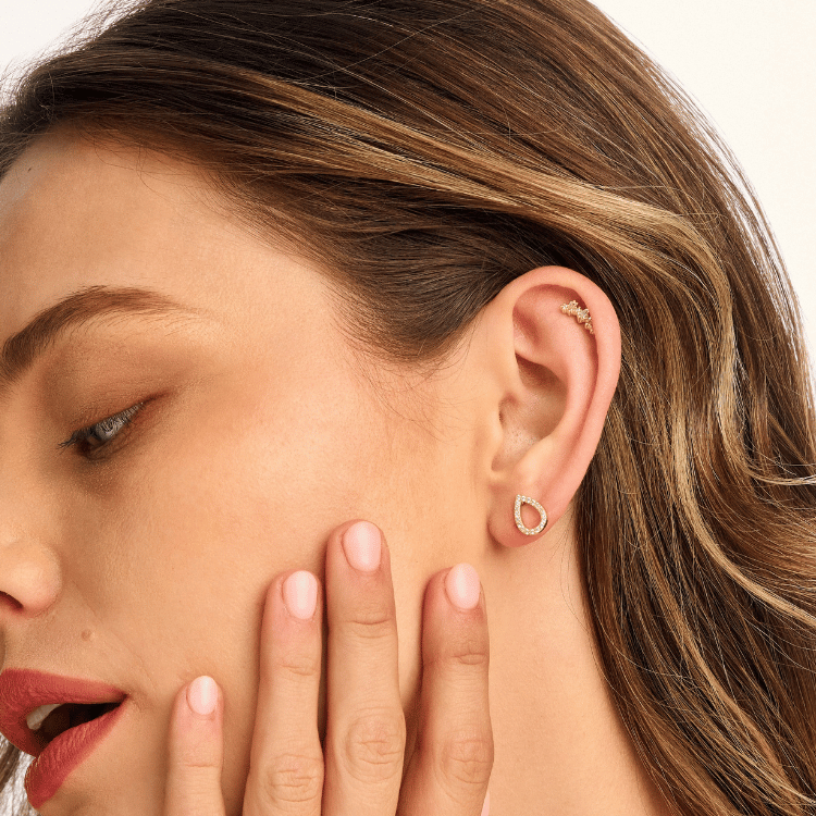Model wearing a tear-shaped earring, styled for an elegant and minimalist look