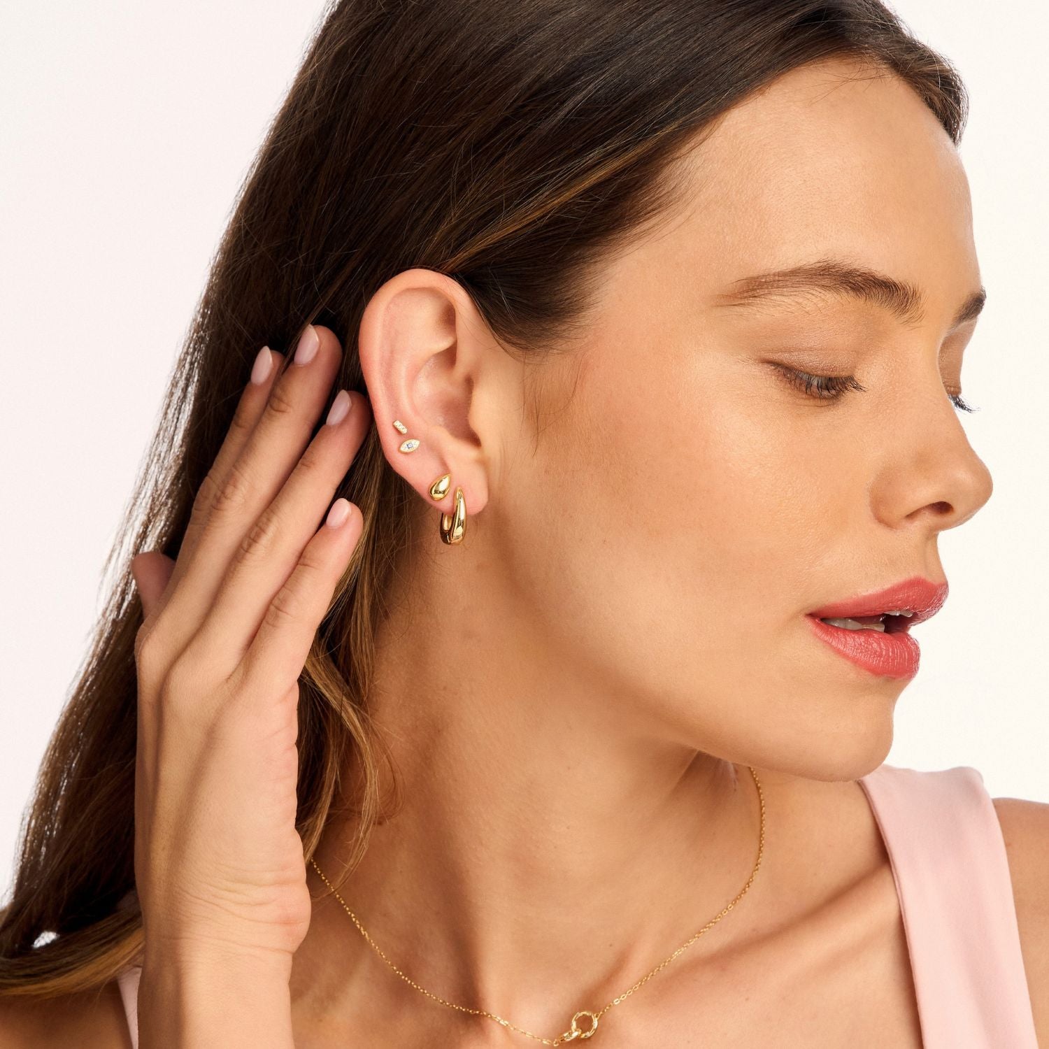 Model wearing small gold dome stud earrings, highlighting their sleek, minimalist design. A modern, on-trend accessory perfect for everyday wear