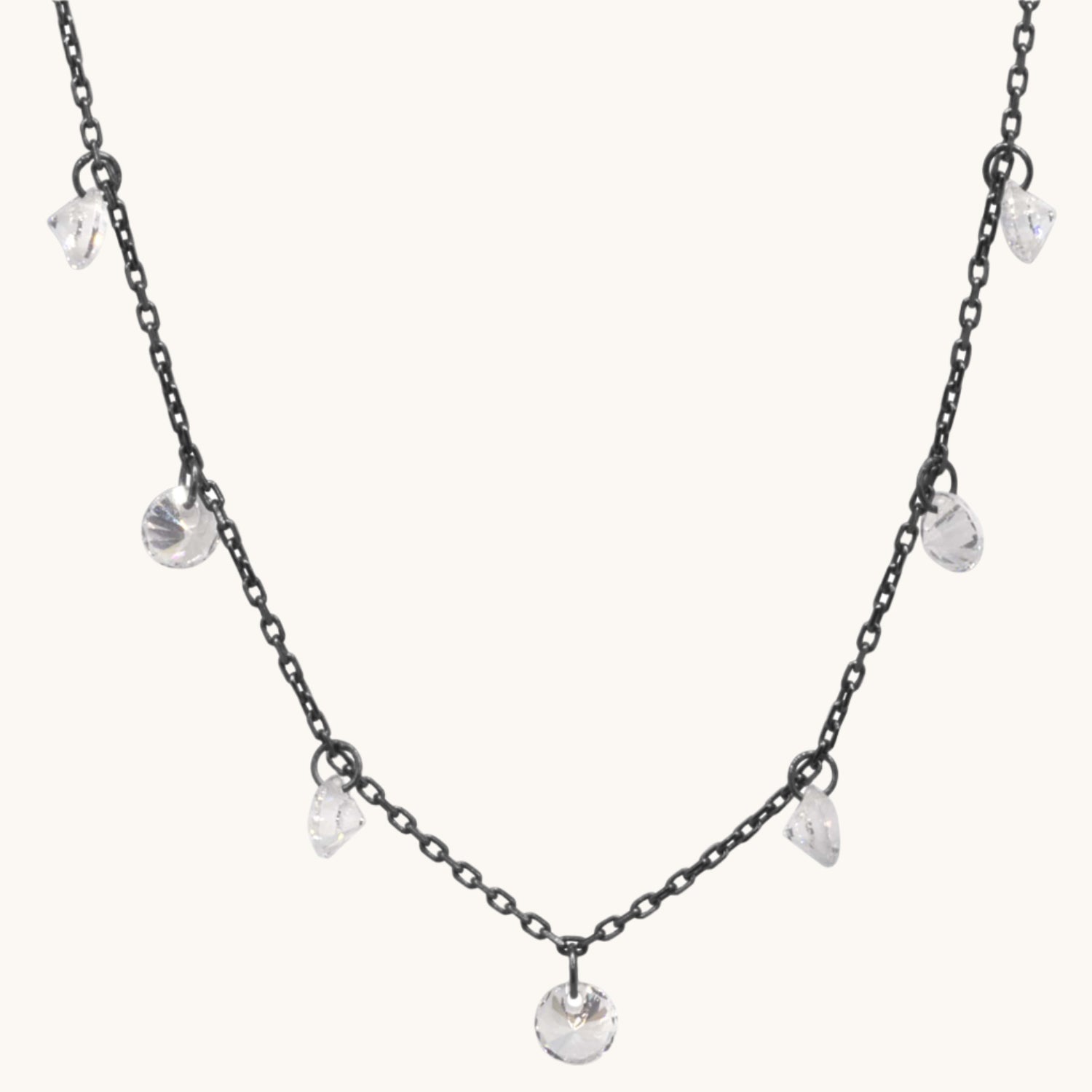 Pretty Cubic Zirconia Drop Necklace with black chain pictured on warm cream background