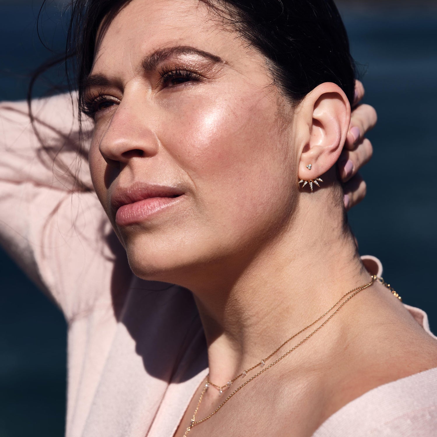 Dark haired Model wears earring with decorative cuff