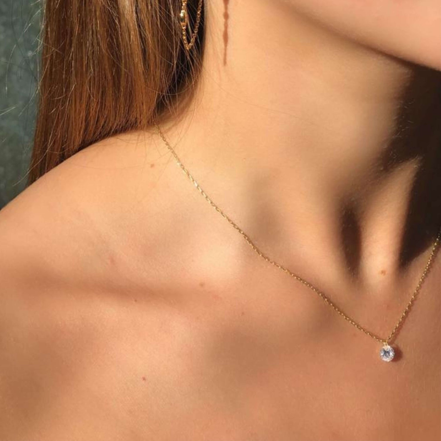 Model wears single cubic zirconia drop necklace worn alone