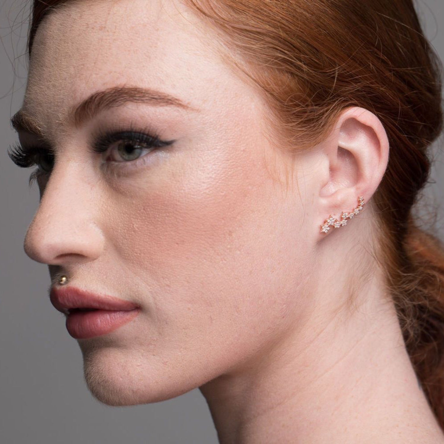 Red haired model wears beautiful star cuff earrings